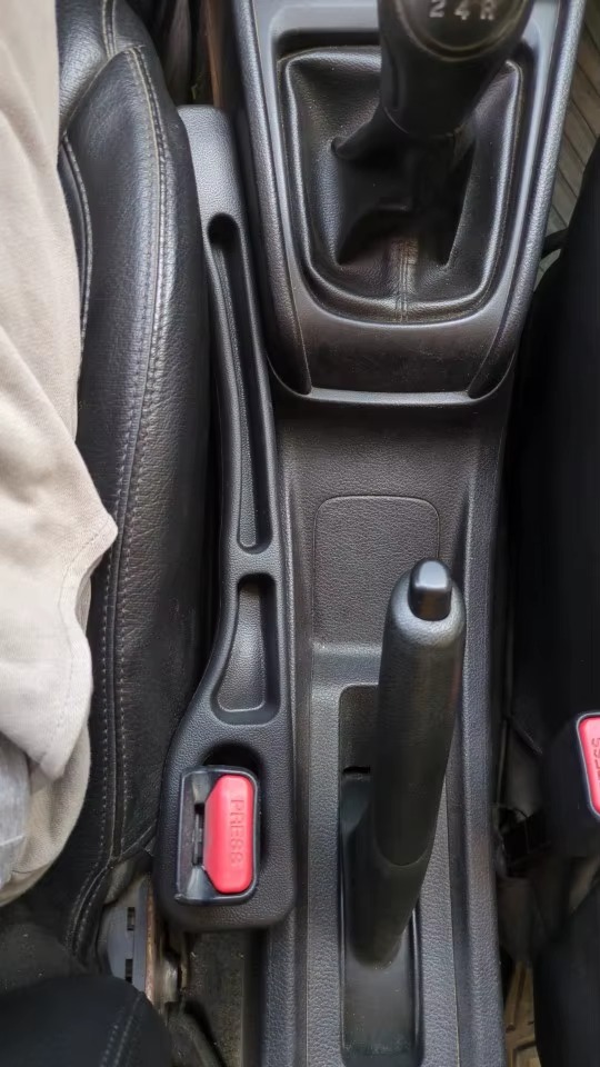 Black gap filler installed in car with manual shift